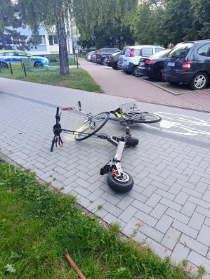 rower i hulajnoga leżą na drodze rowerowej