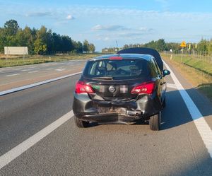czarny opel z rozbitym tyłem stojący na drodze
