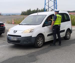 policjant badający na trzeźwość kierowcę Peugeota
