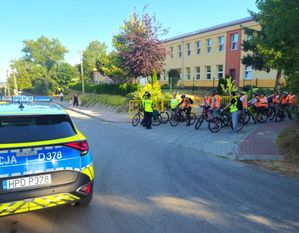 policjantka rozmawiająca z dziećmi koło szkoły