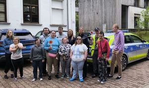 policjantki z uczestnikami pogadanki stoją obok radiowozu