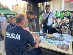 dwaj mężczyźni rozmawiający z policjantami przy stoisku