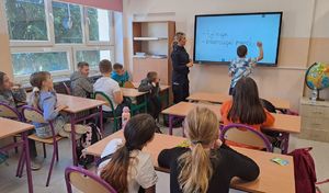 policjantka z dzieckiem przy tablicy w klasie