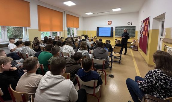 policjantka prowadząca prelekcję w klasie pełnej uczniów