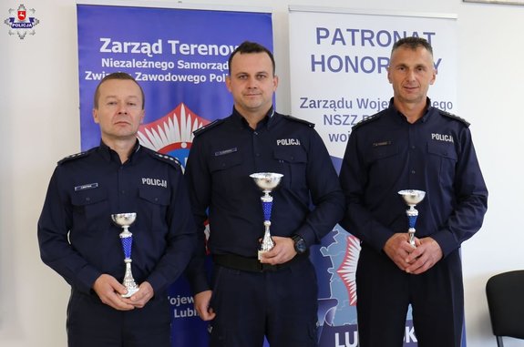 trzech policjantów dyżurnych z pucharami