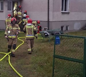 strażacy obok budynku