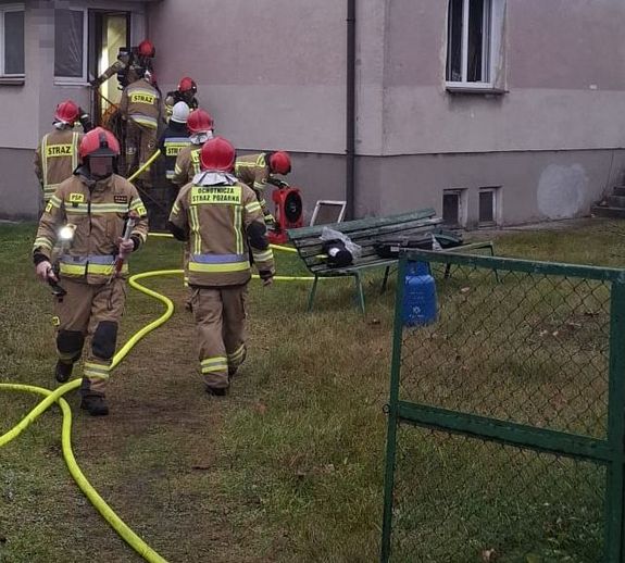 strażacy obok budynku