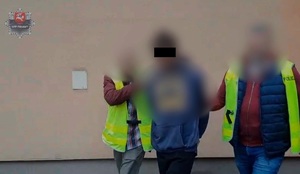 policjanci prowadzący zatrzymanego