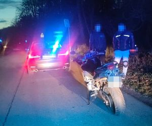 dwóch mężczyzn obok motocykla w tle nieoznakowany radiowóz BMW