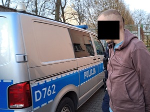 zatrzymany mężczyzna na tle radiowozu