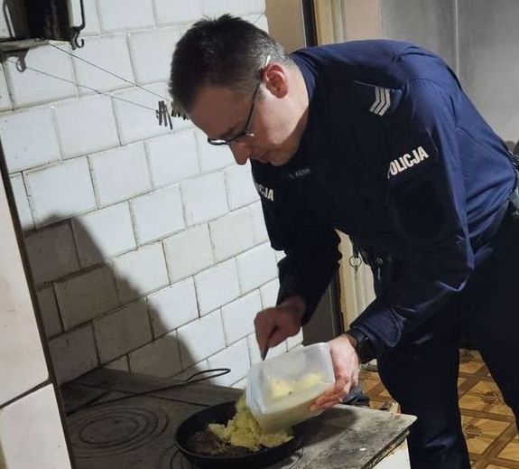 policjant przygotowujący posiłek na kuchni węglowej