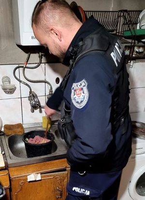 policjant przygotowujący posiłek dla psa w wiaderku stojącym w zlewie