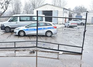 wyważona brama za nią radiowóz