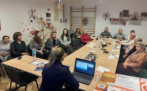 policjantka prezentująca seniorom informacje dotyczące oszustw