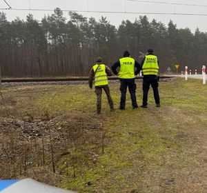 trzech funkcjonariuszy obok torów
