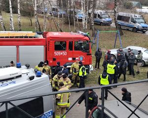 wozy policyjne i strażackie oraz funkcjonariusze na placu