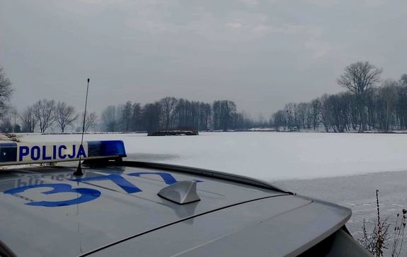 radiowóz obok zamarzniętego stawu