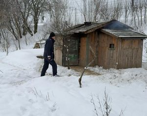 dzielnicowy obok drewnianej chatki