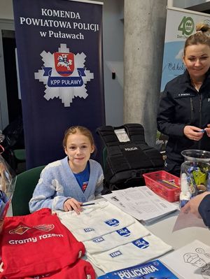 dziewczynka przy stoisku policyjnym obok policjantka