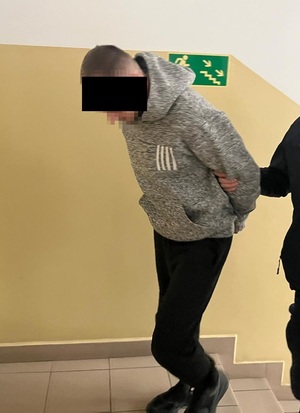 zatrzymany prowadzony w kajdankach przez policjanta