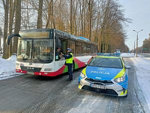 policjant przeprowadzający kontrolę trzeźwości kierowcy autobusu