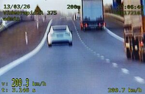 zrzut ekranu z videorejestratora na lewym pasie drogi s17 biała tesla i napis 209 km na godzinę na prawym pasie dwie ciężarówki