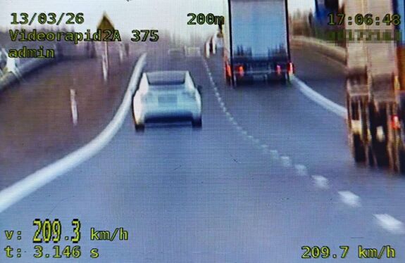 zrzut ekranu z videorejestratora na lewym pasie drogi s17 biała tesla i napis 209 km na godzinę na prawym pasie dwie ciężarówki