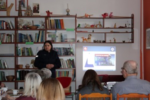 ekran z informacjami Oszustwa na legendę obok prowadząca prelekcję policjantka