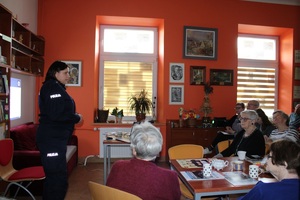 policjantka stojąca przed ludźmi w trakcie prelekcji