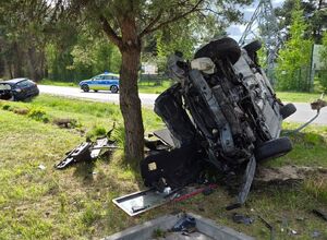 rozbite volvo na boku pod drzewem w tle opel na ulicy radiowóz