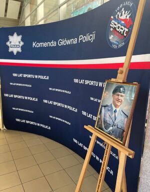 zdjęcie policjanta na tle ścianki Komenda Główna Policji
