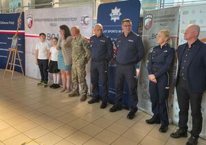 policjanci oraz rodzina policjanta pozujący do wspólnego zdjęcia