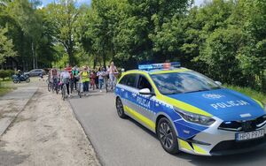policyjny radiowóz za nim rowerzyści