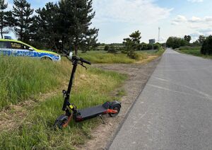 hulajnoga przy drodze w tle radiowóz