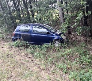 niebieska toyota w rowie oparta przodem o drzewo