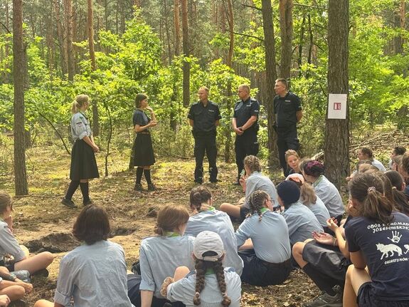 harcerze w lesie z nimi trzech policjantów