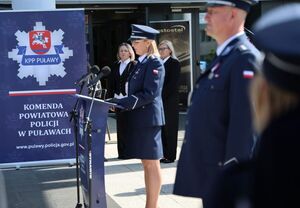 nadkomisarz Agnieszka Falandysz przy mównicy w tle pracownice