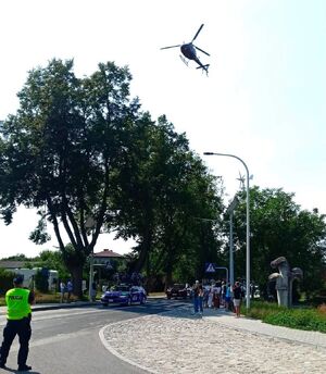 policjant na skrzyżowaniu patrzący na nadjeżdżający peleton