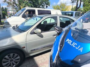 Motocykl policyjny a w tle zaparkowane pojazdy