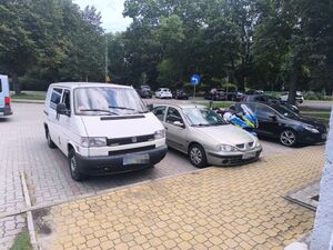Pojazd mki Volkswagen na parkingu a obok motocykl policyjny