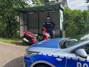policjant stojący na przystanku obok mężczyzny ze skuterem