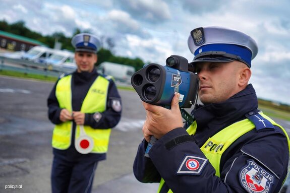 policjanci ruchu drogowego jeden z nich trzyma miernik prędkości