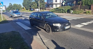 pojazd na drodze przy przejściu dla pieszych, w tle widać radiowóz