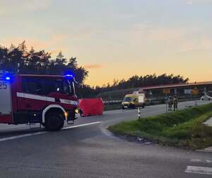 miejsce wypadku żółty bus obok czerwony parawan i wozy straży pożarnej