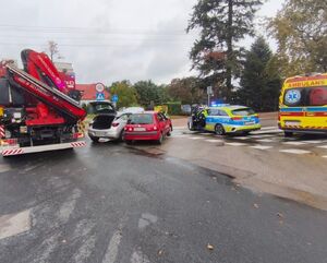 dwa zderzone samochody wozy służb na skrzyżowaniu