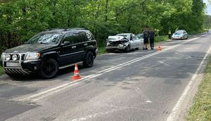 miejsce zdarzenia i uszkodzone pojazdy marki Jeep oraz BMW. Na drugim planie widać radiowóz i funkcjonariuszy